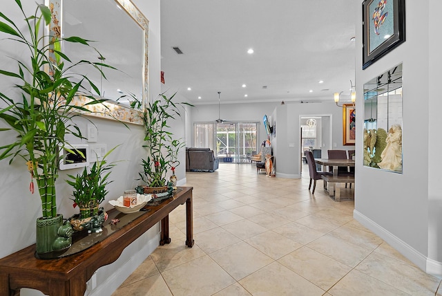 hallway featuring light tile patterned flooring and ornamental molding