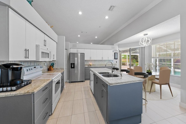 kitchen with a sink, appliances with stainless steel finishes, light tile patterned flooring, and gray cabinets