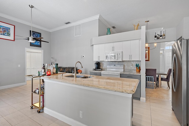 kitchen with sink, light tile patterned floors, an island with sink, white appliances, and white cabinets