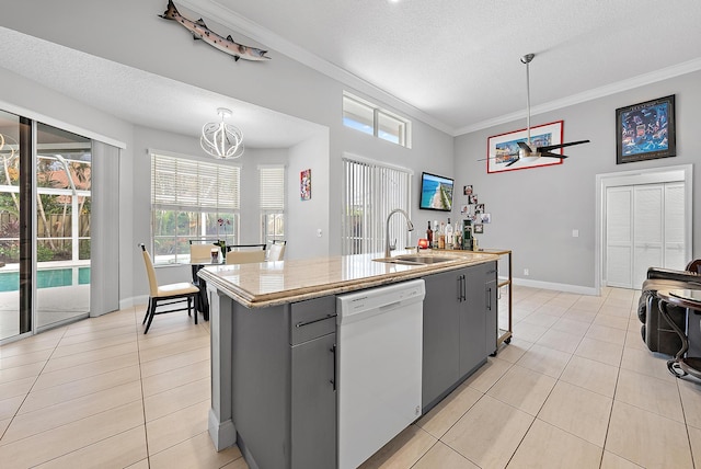 kitchen with pendant lighting, sink, gray cabinetry, white dishwasher, and a center island with sink