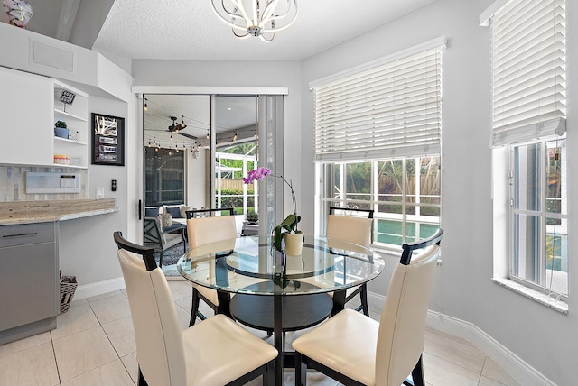 dining area with light tile patterned floors, a notable chandelier, and a textured ceiling