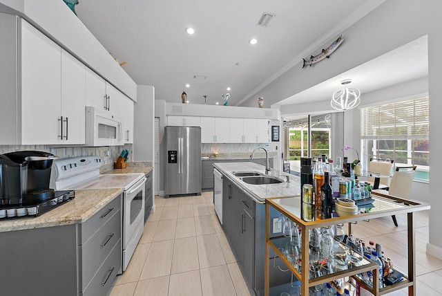 kitchen with white appliances, gray cabinets, sink, and white cabinets