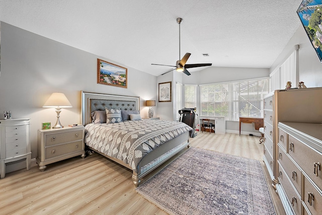 bedroom featuring visible vents, ceiling fan, light wood-type flooring, vaulted ceiling, and a textured ceiling