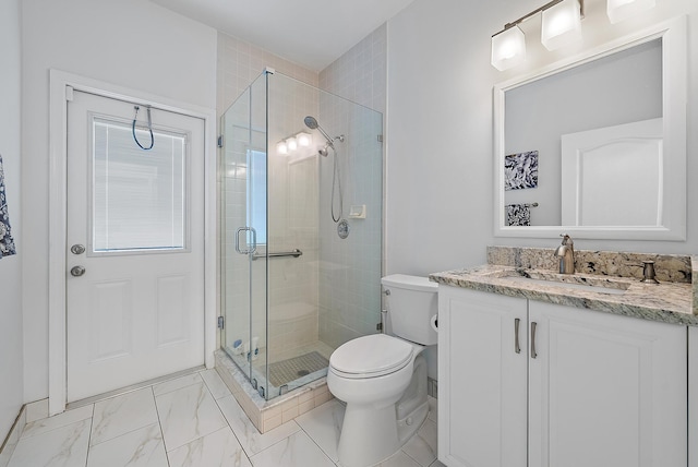 bathroom featuring vanity, a shower with door, and toilet