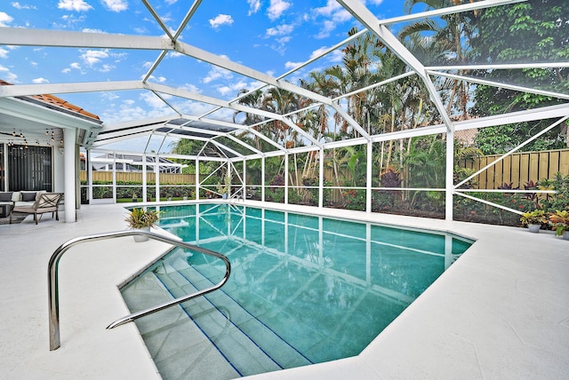 view of swimming pool featuring a patio area, glass enclosure, a fenced backyard, and a fenced in pool