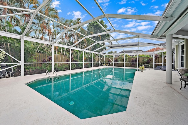 view of swimming pool featuring glass enclosure, a patio, a fenced in pool, and a fenced backyard