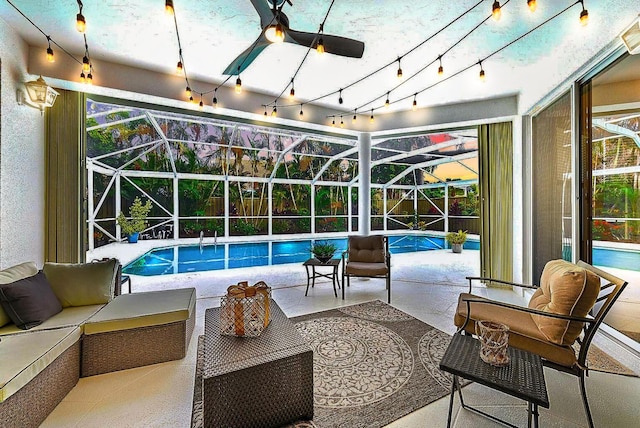 outdoor pool featuring glass enclosure, outdoor lounge area, a patio, and a ceiling fan