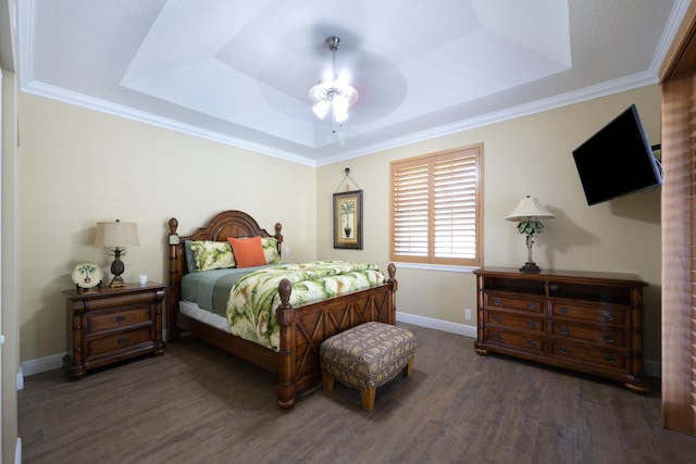 bedroom with dark hardwood / wood-style flooring, a tray ceiling, and ceiling fan