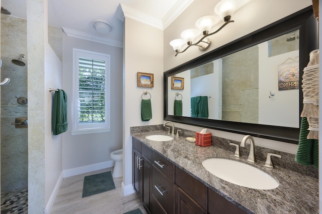 bathroom featuring crown molding, tiled shower, and vanity