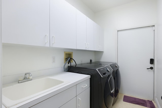 clothes washing area with sink, cabinets, and washing machine and clothes dryer