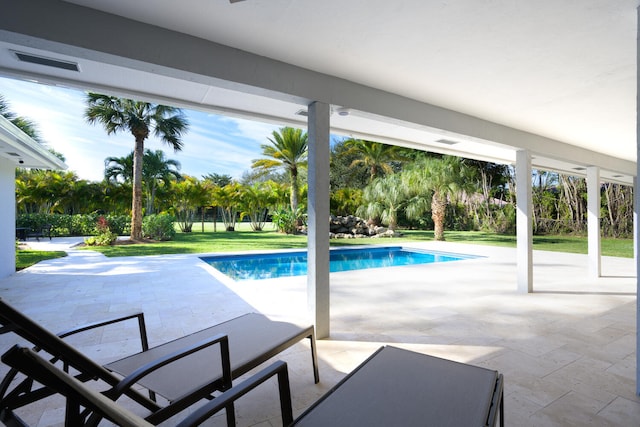 view of swimming pool featuring a patio and a yard