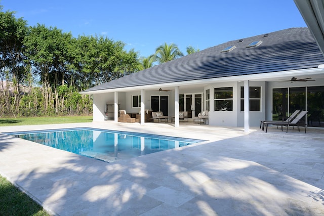 view of pool with an outdoor living space, a patio, and ceiling fan