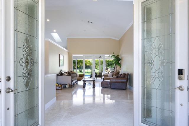 foyer with crown molding, french doors, and a towering ceiling