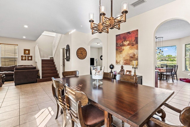 dining room with an inviting chandelier, light tile patterned floors, and a textured ceiling