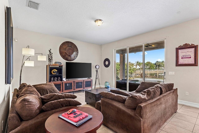 living room featuring a textured ceiling and light tile patterned floors