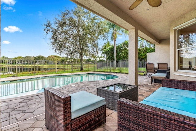 view of pool with a patio, a water view, and ceiling fan