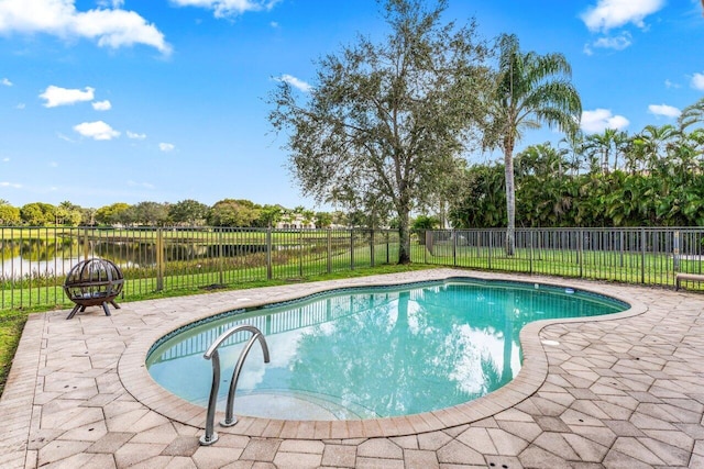 view of swimming pool featuring a water view, a patio area, and a fire pit