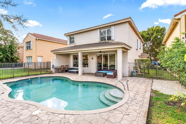 rear view of property with a fenced in pool, an outdoor hangout area, a patio, and ceiling fan