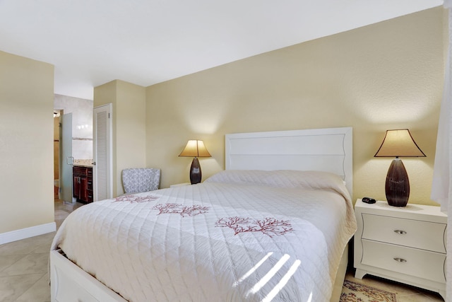 tiled bedroom featuring a closet and ensuite bathroom