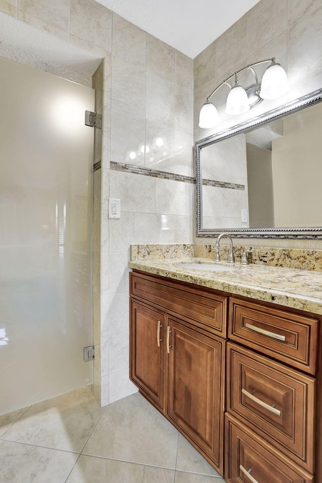 bathroom featuring tile patterned floors, an enclosed shower, tile walls, and vanity