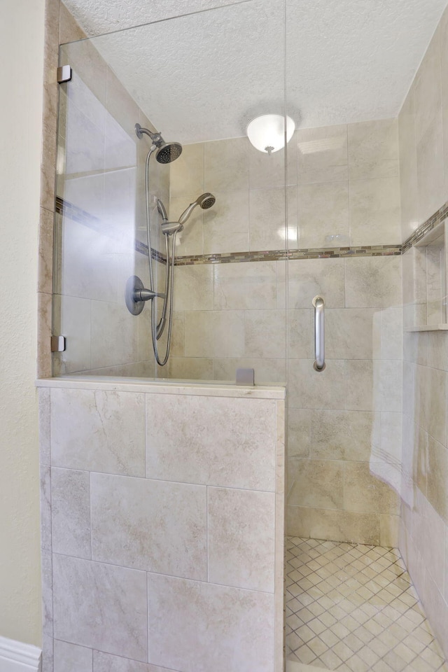 bathroom with walk in shower and a textured ceiling