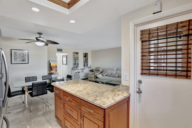 kitchen with light stone countertops and ceiling fan