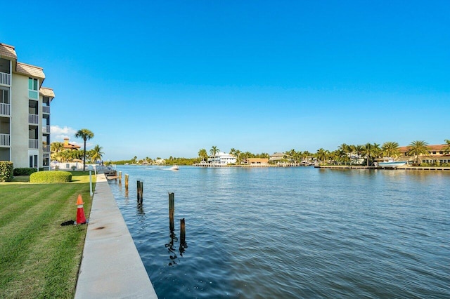 view of dock featuring a water view and a yard