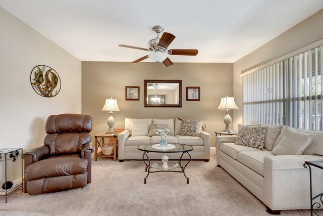 living room featuring light tile patterned floors, ceiling fan with notable chandelier, and a textured ceiling