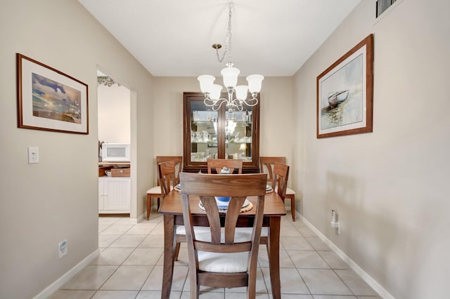 tiled dining area featuring a notable chandelier