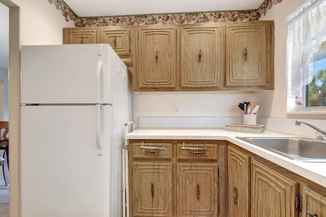 kitchen featuring white fridge and sink