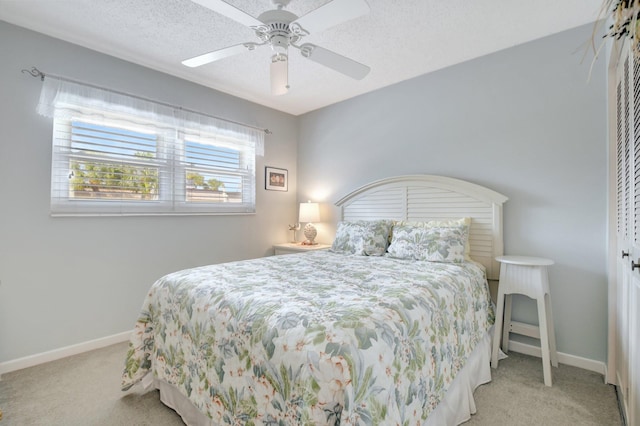 bedroom with ceiling fan, light carpet, and a textured ceiling