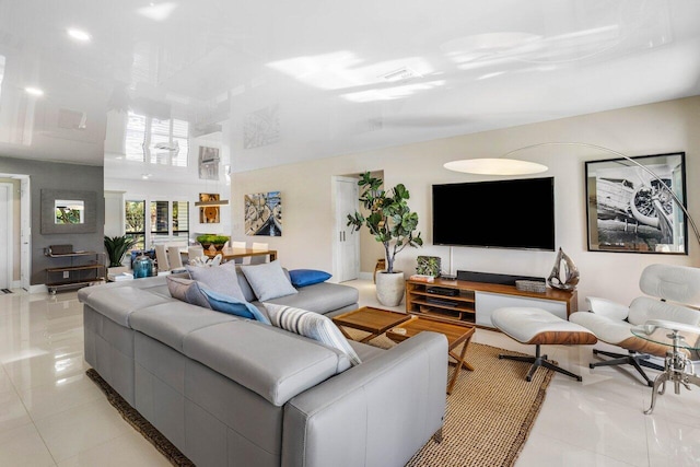 living room with light tile patterned flooring and a towering ceiling