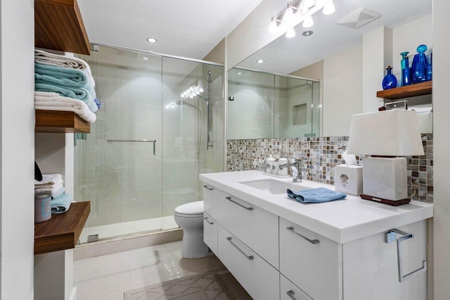 bathroom with tasteful backsplash, vanity, toilet, a shower with door, and a textured ceiling