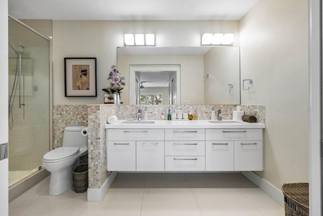 bathroom featuring tile patterned floors, toilet, tile walls, a textured ceiling, and vanity