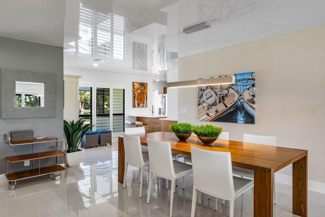 dining area featuring a towering ceiling