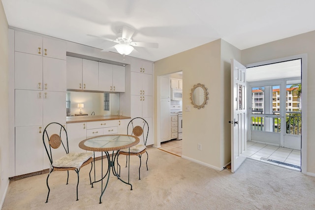 dining space featuring light colored carpet and ceiling fan