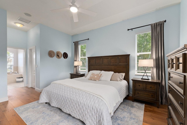 bedroom featuring ceiling fan, light wood-type flooring, and ensuite bath