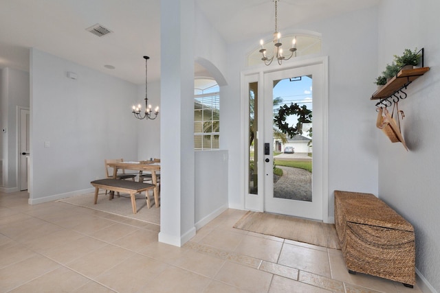 tiled foyer featuring an inviting chandelier