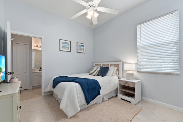 bedroom with light tile patterned floors, ensuite bath, and ceiling fan