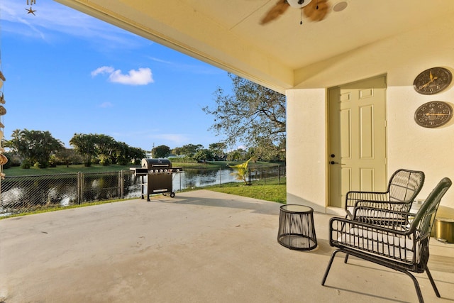 view of patio / terrace featuring a water view, ceiling fan, and area for grilling