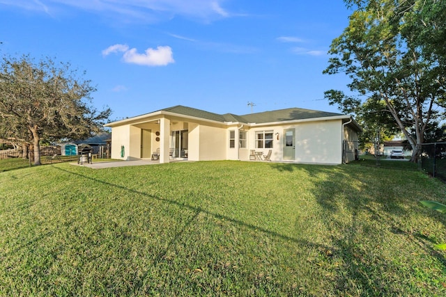 rear view of house featuring a patio and a yard