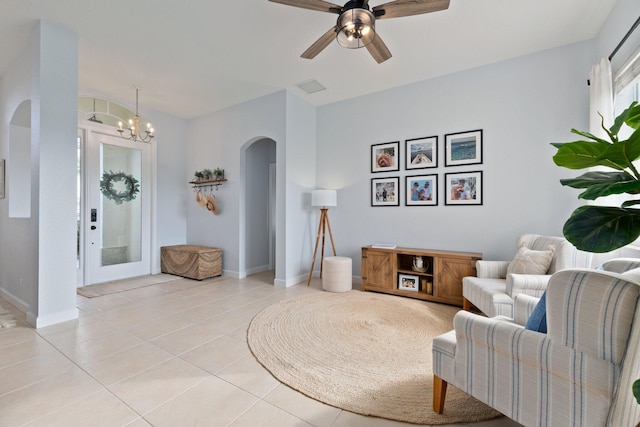 living room featuring ceiling fan with notable chandelier and light tile patterned floors