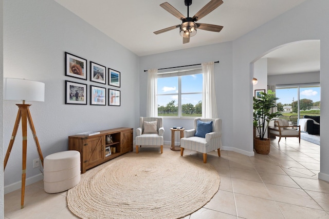 living area featuring a wealth of natural light, ceiling fan, and light tile patterned floors