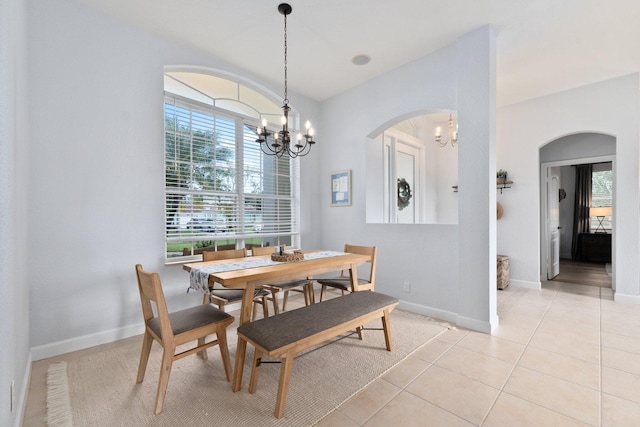 tiled dining space featuring an inviting chandelier and a healthy amount of sunlight