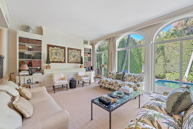 carpeted living room with decorative columns and crown molding