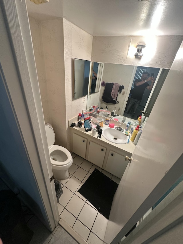 bathroom featuring vanity, tile patterned floors, and toilet