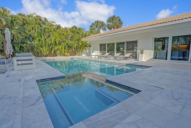 view of pool with an in ground hot tub and a patio area