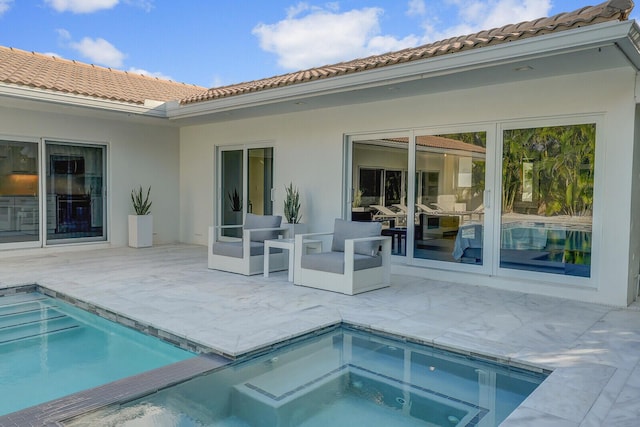 back of house with a swimming pool with hot tub and a patio