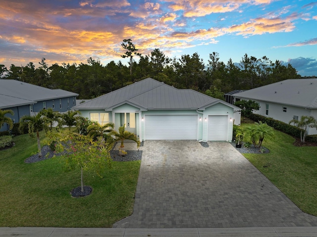 view of front of property with a yard and a garage