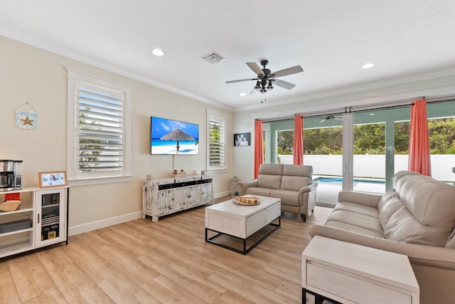 living room featuring ceiling fan, ornamental molding, light hardwood / wood-style flooring, and a textured ceiling